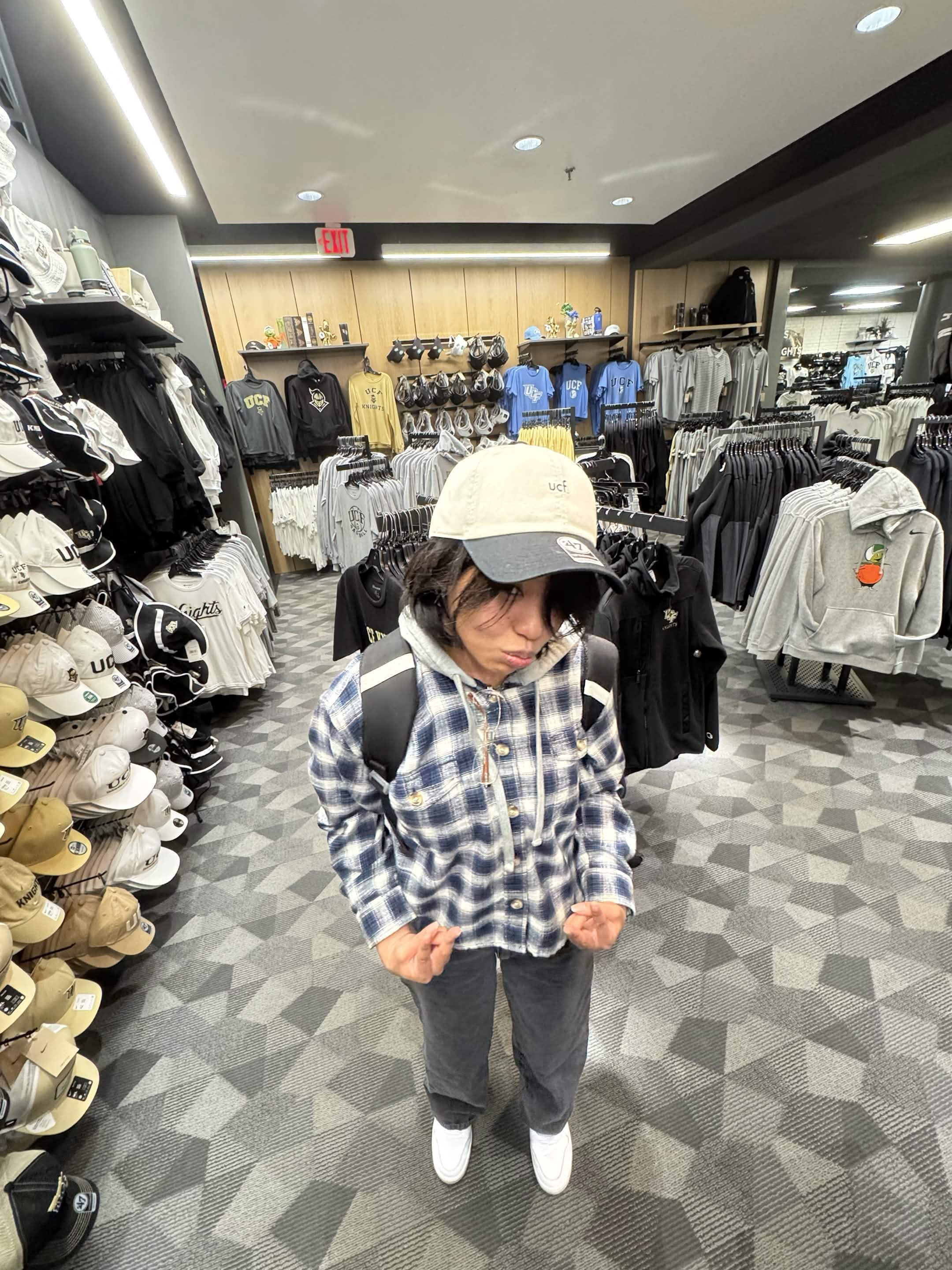 Samantha trying on UCF merch in a store